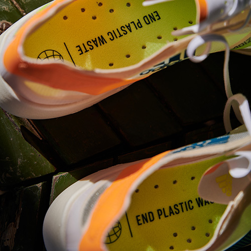 A pair of Adidas shoes with insoles that have the text imprinted "End plastic waste."